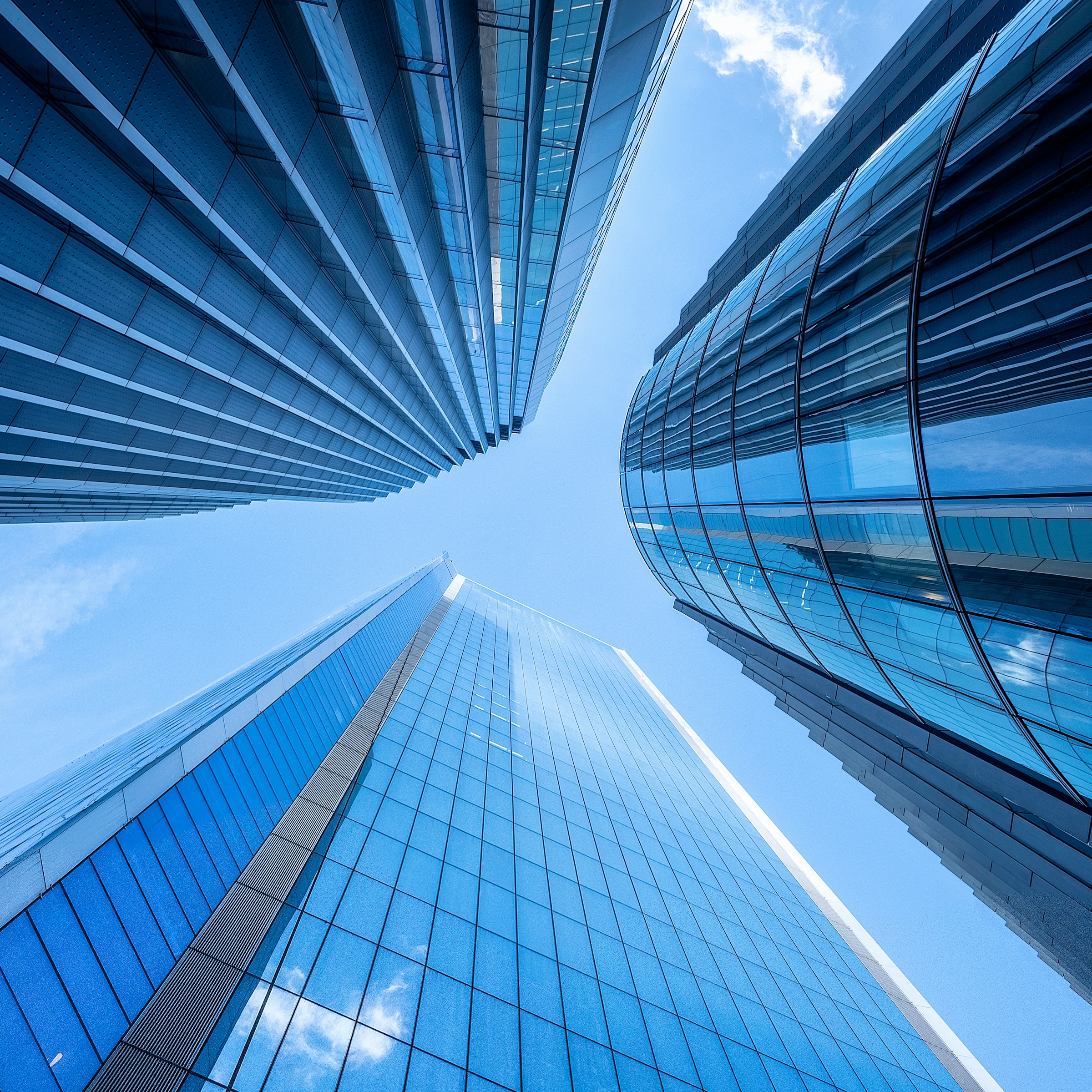 Glass buildings rising toward an open sky